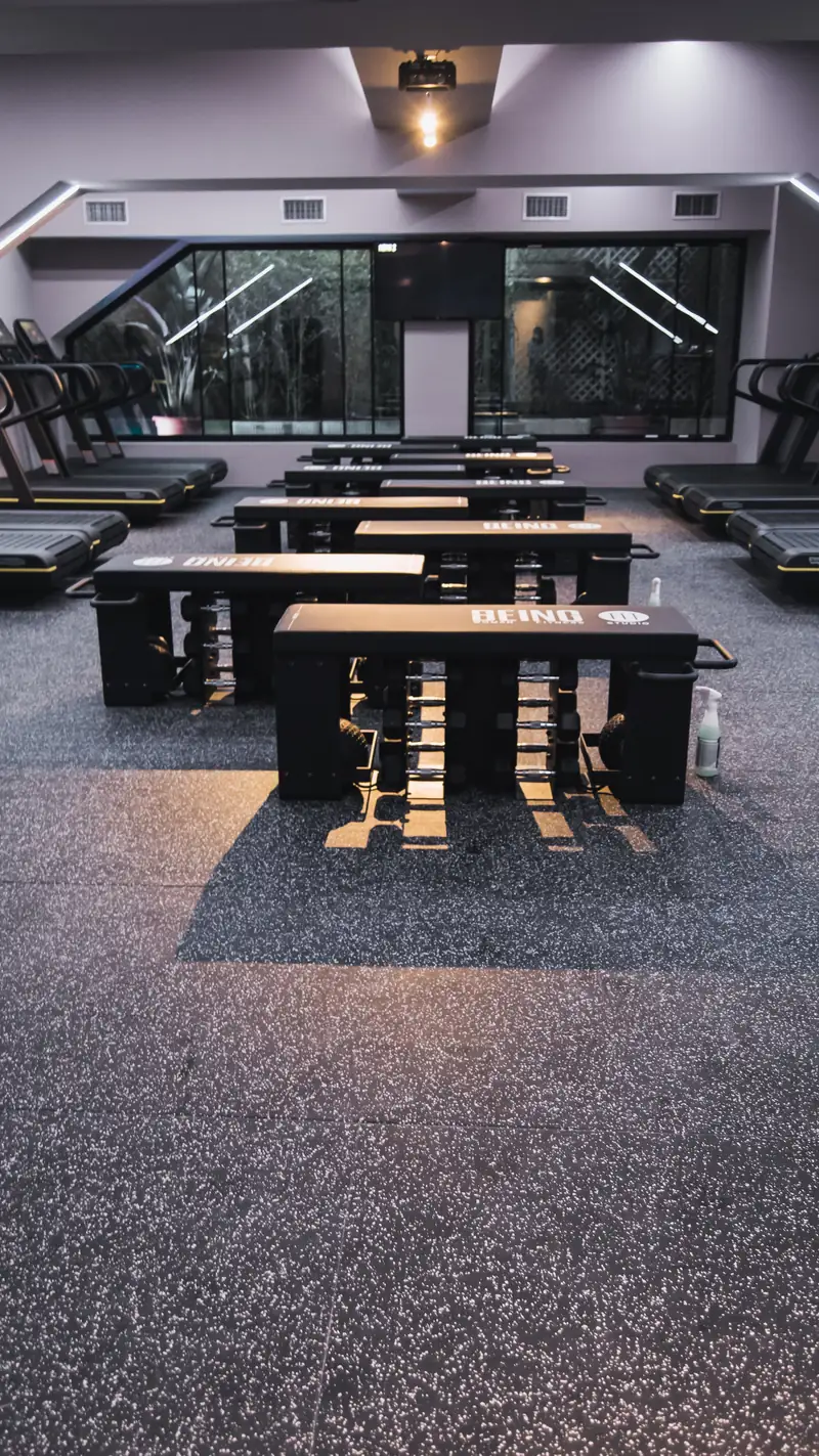 Equipamiento de fuerza y cardio alineado en la sala de Being Fit